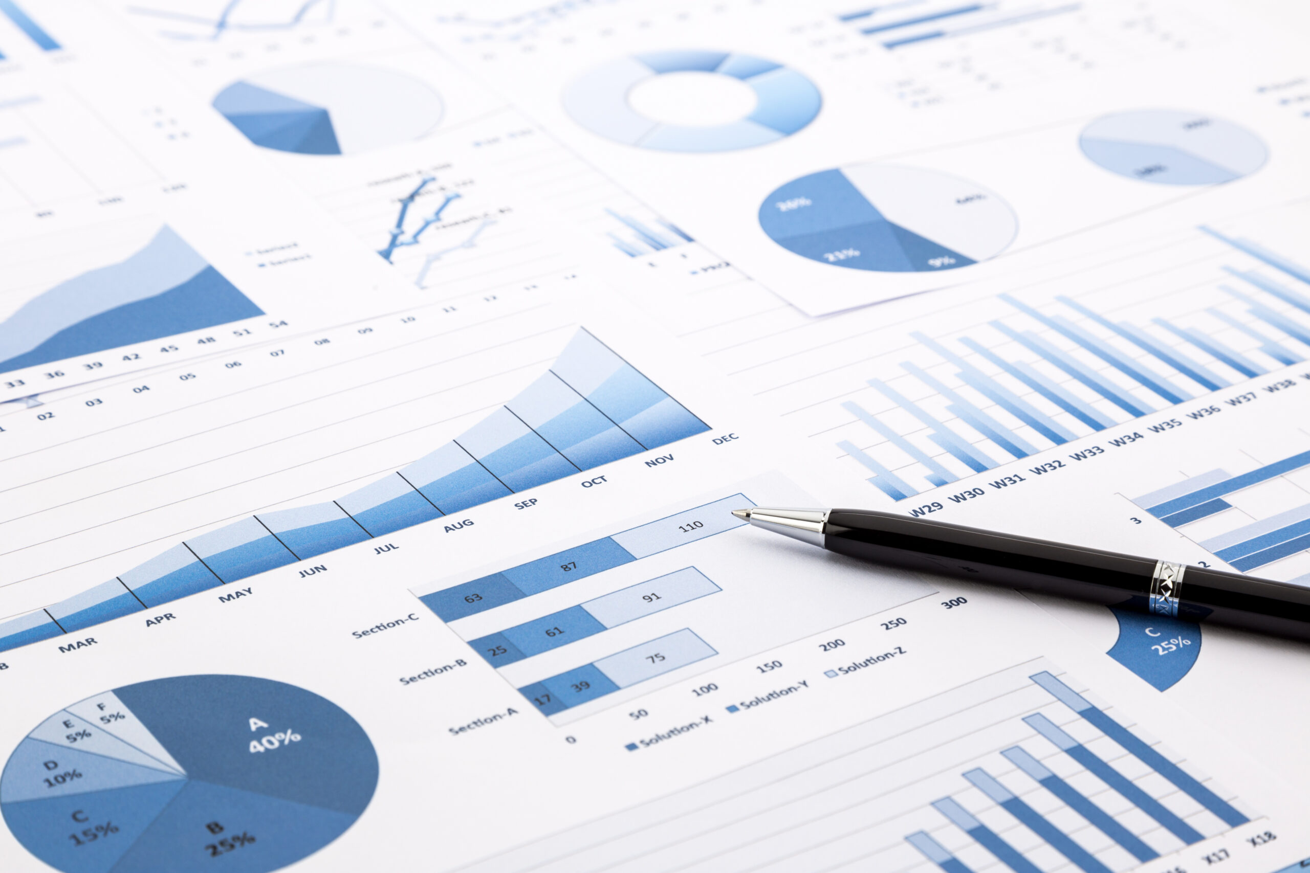 pen on blue charts, graphs, data and reports background for education and business concepts